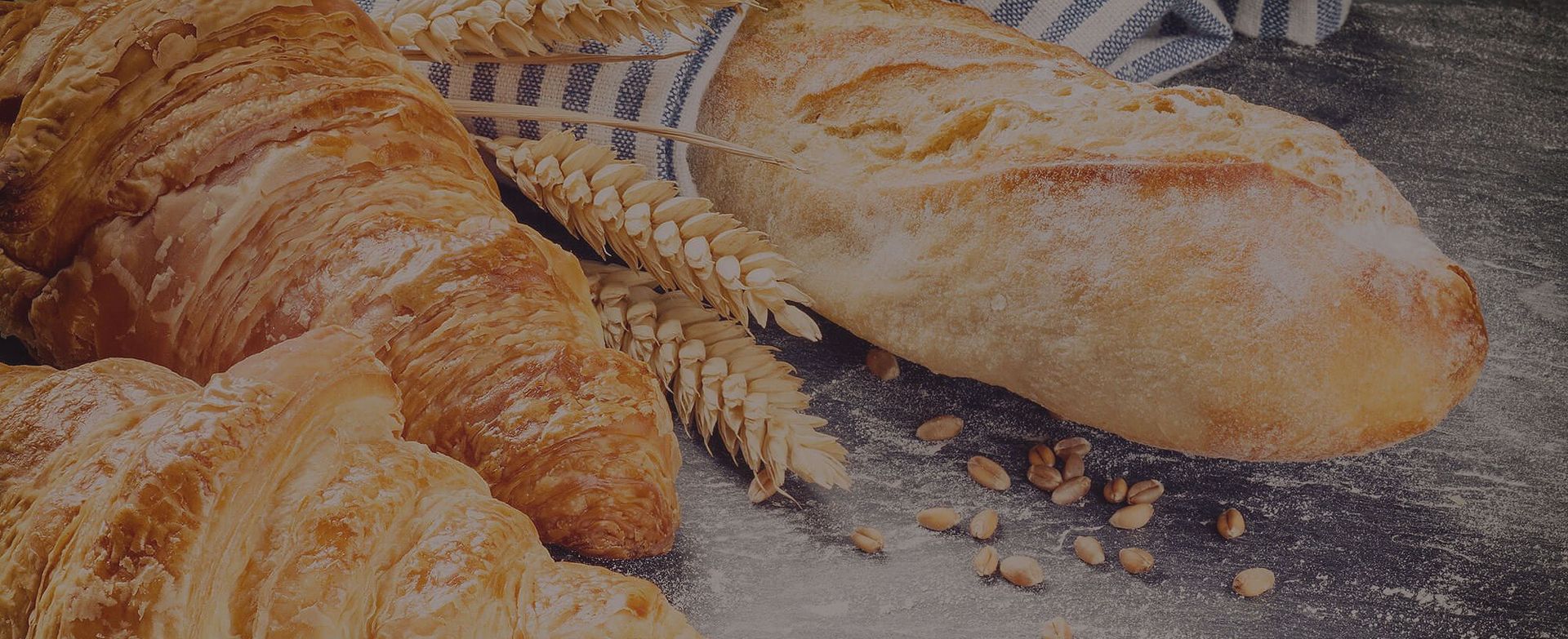 Eine Auswahl an Croissants und Broten auf einem gedeckten Tisch.